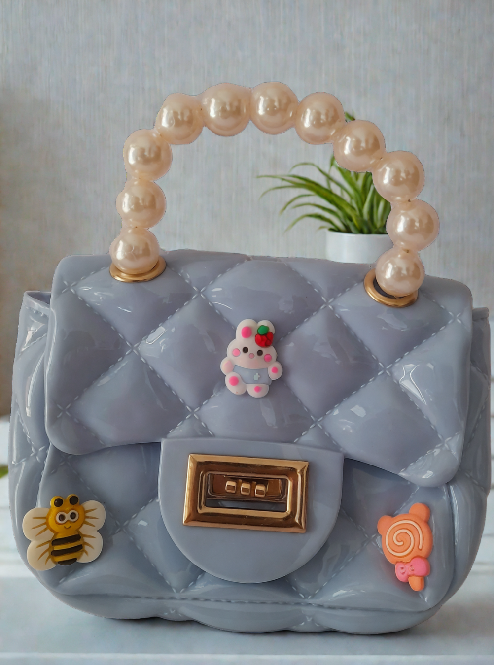 Silicon pearl sling bag with golden chain strap and pearl handle – stylish and durable mini shoulder bag for girls and women in pastel blue color, available online in India.
