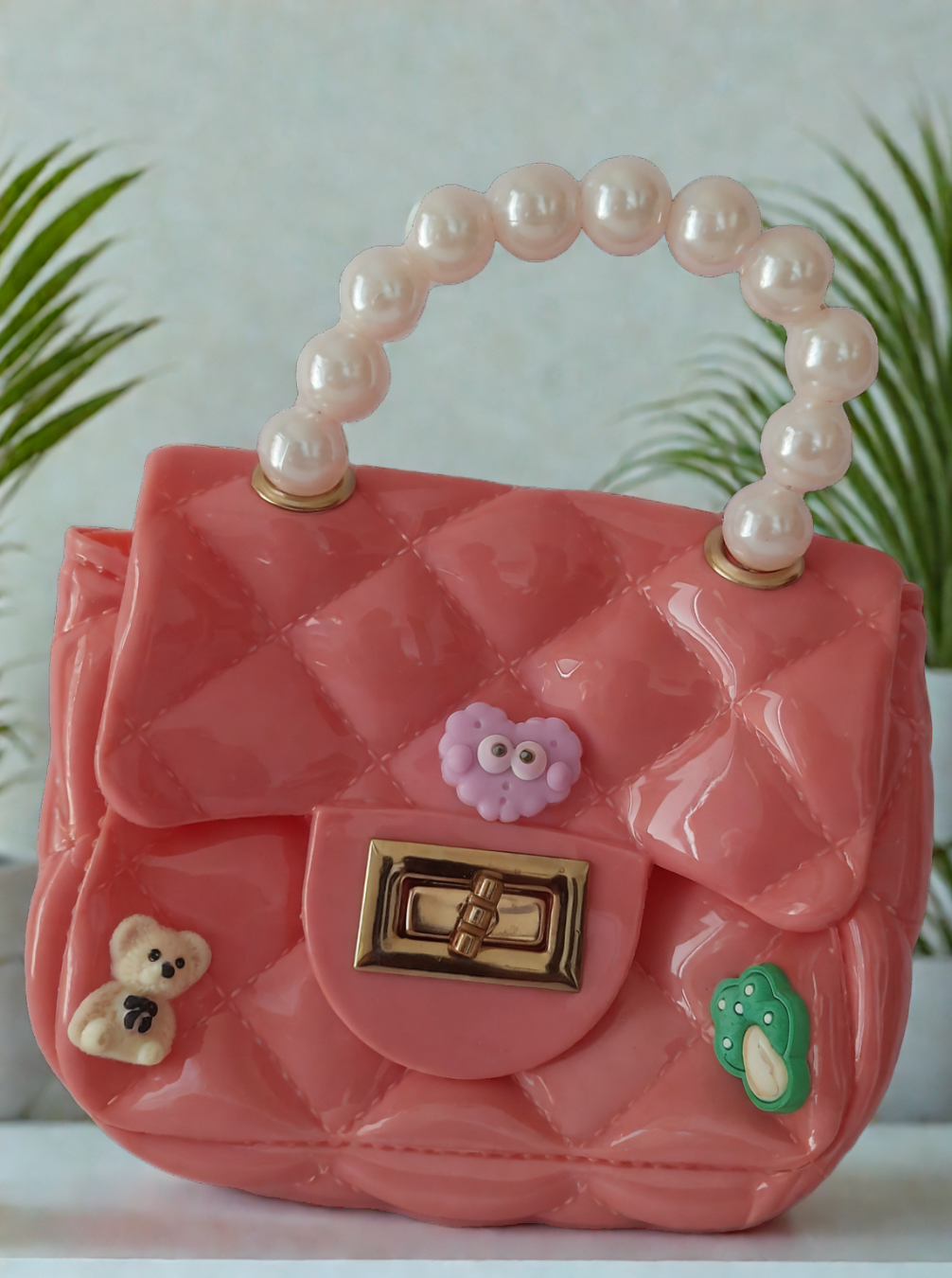 Silicon pearl sling bag with golden chain strap and pearl handle – stylish and durable mini shoulder bag for girls and women in peach pink, available online in India.
